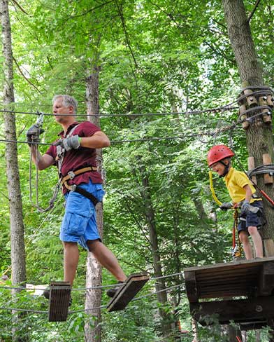 Mann und Kind im Parkour tree2tree Hochseilgarten