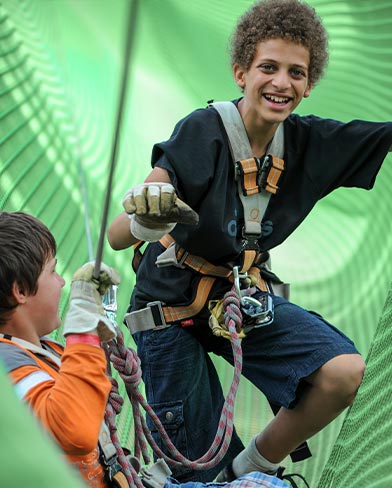 Zwei Jungs in einem Netz eines Kletterparcours tree2tree Hochseilgarten