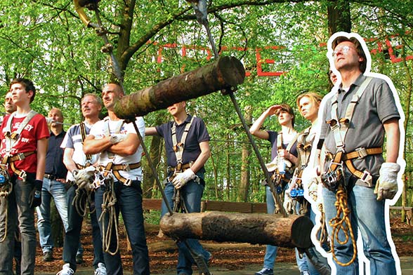 Eine Gruppe am Fuße eines Kletterparcours im Hochseilgarten tree2tree